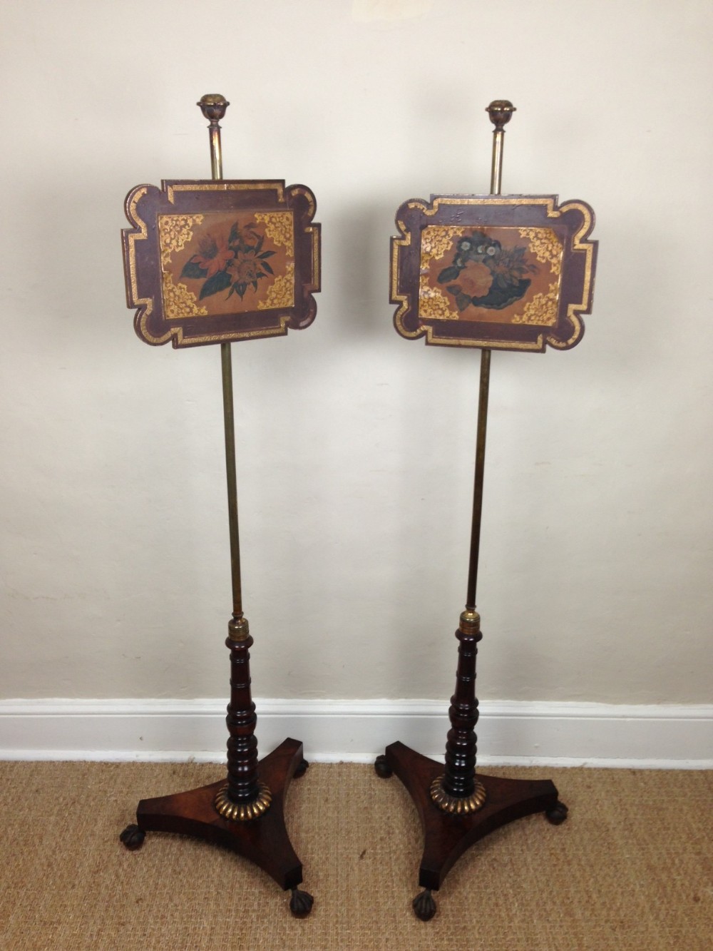 A pair of Regency rosewood and painted pole screens dated 1820