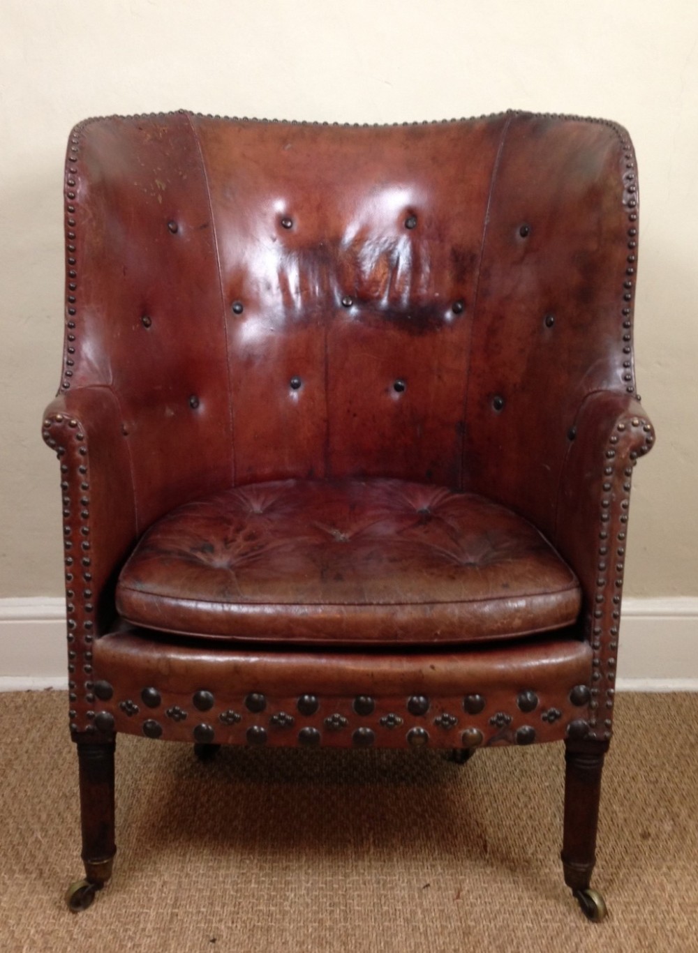A George IV barrel back wing chair in original morocco leather c 1830
