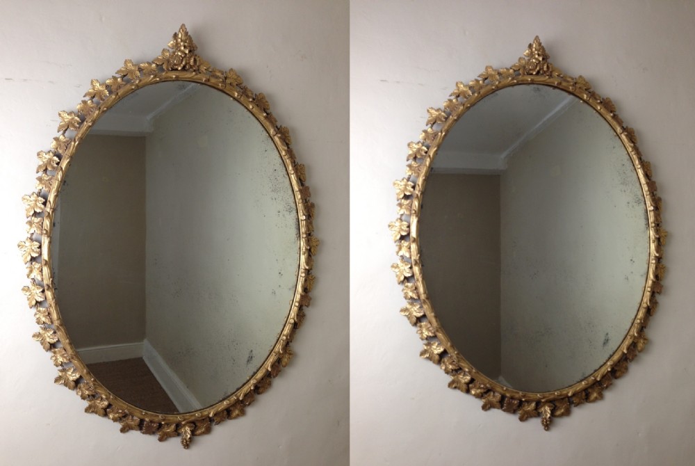 A large pair of Victorian gilt oval mirrors c 1870