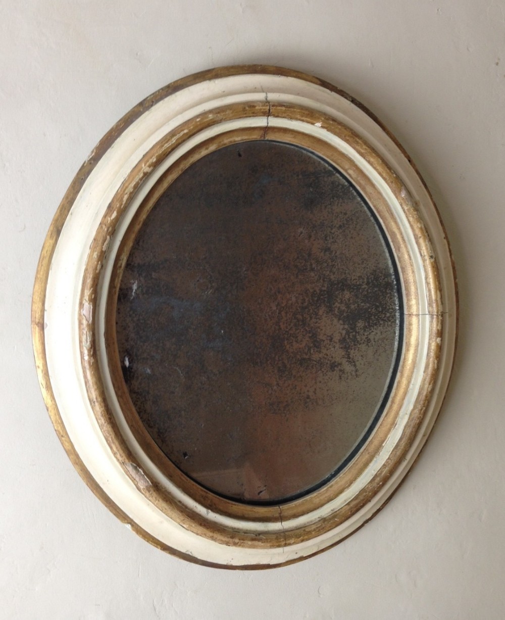 A small mid 19th c painted and gilt oval mirror