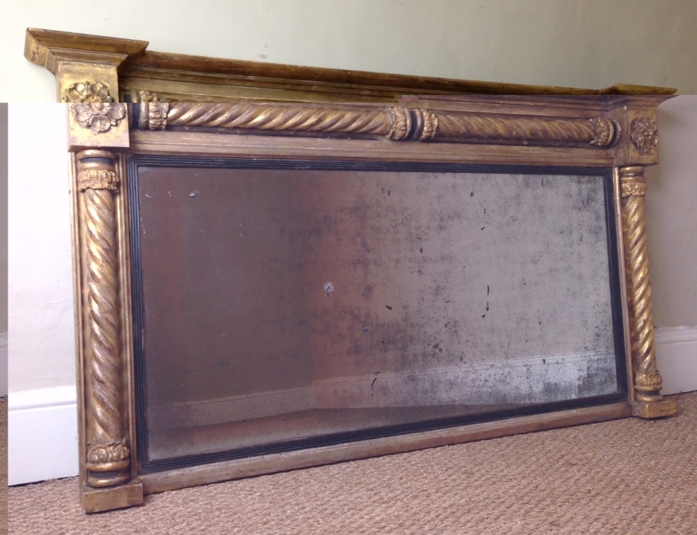 A large Regency gilt and ebonised over mantel mirror