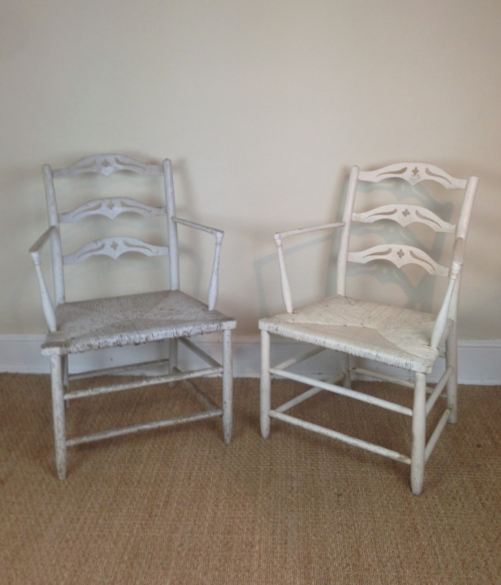 A pair of George 111 white painted elbow chairs c 1790