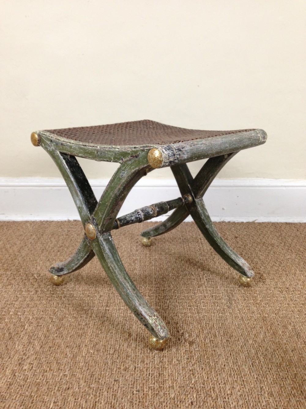 A Regency painted and parcel gilt saddle seated stool c 1820