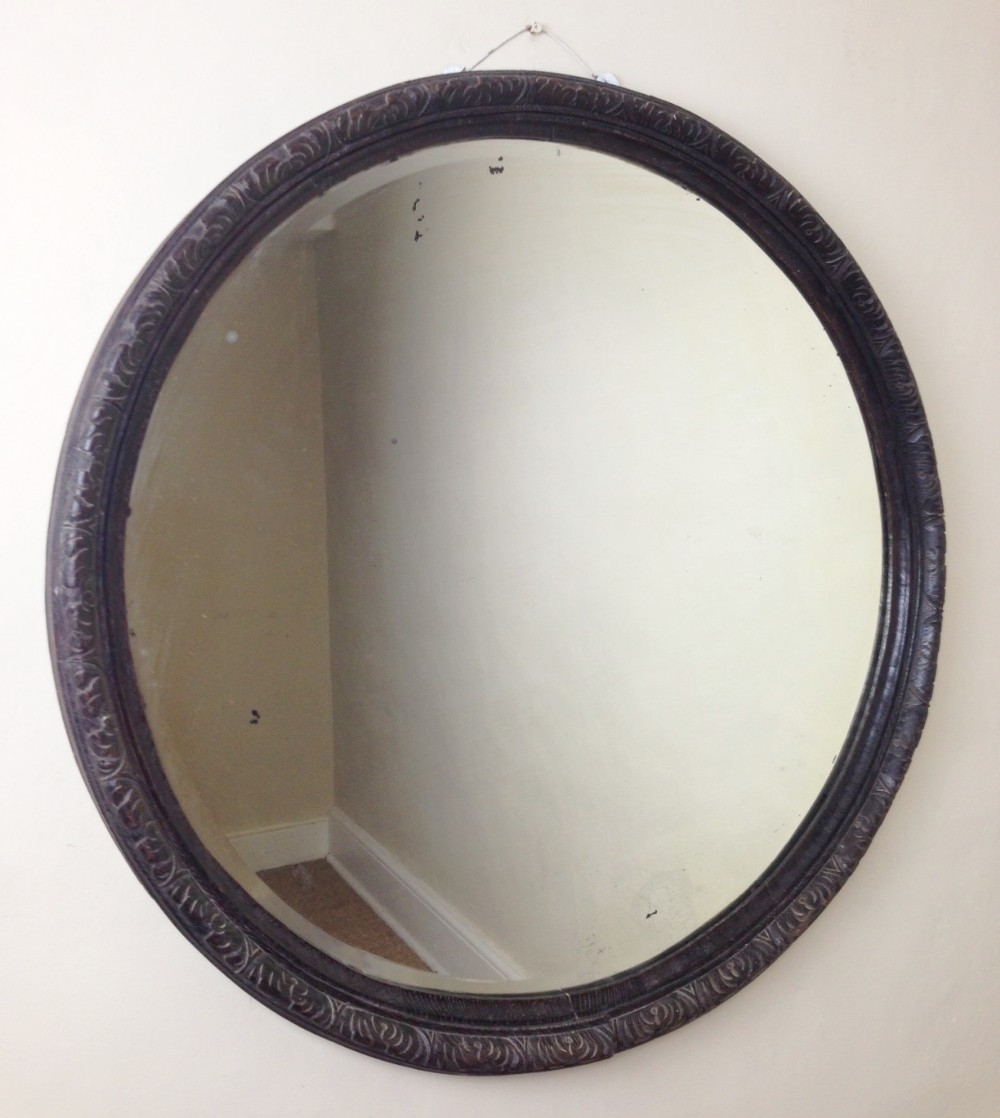 A large Victorian circular carved and ebonised oak mirror c 1880