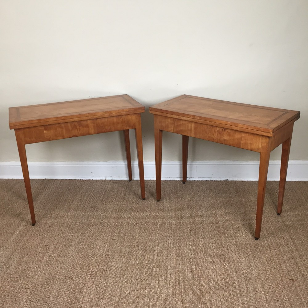 A pair of early 19th century continental satinbirch and rosewood rectangular fold over card tables circa 1820