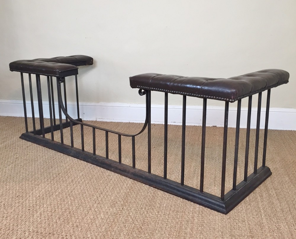 A large Edwardian cast-iron club fender circa 1910 with dark brown leather top.