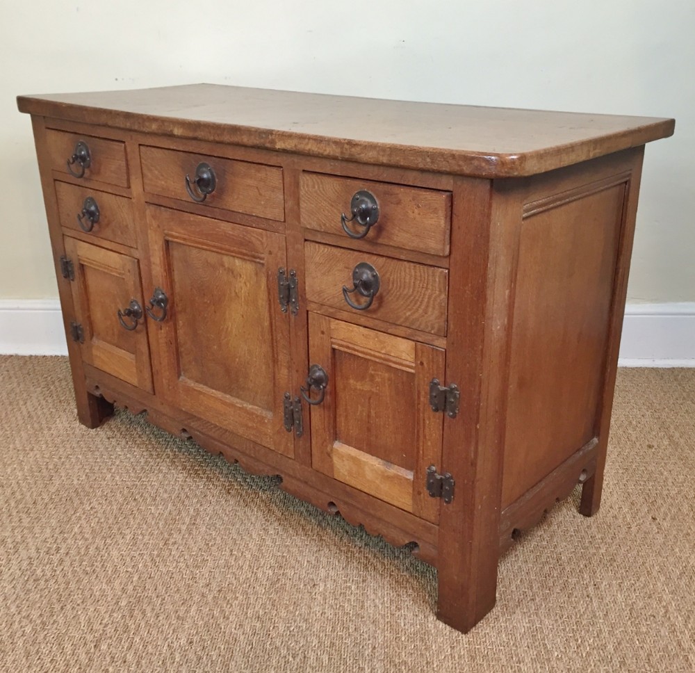 An Arts and Crafts burr oak dresser base c 1920 