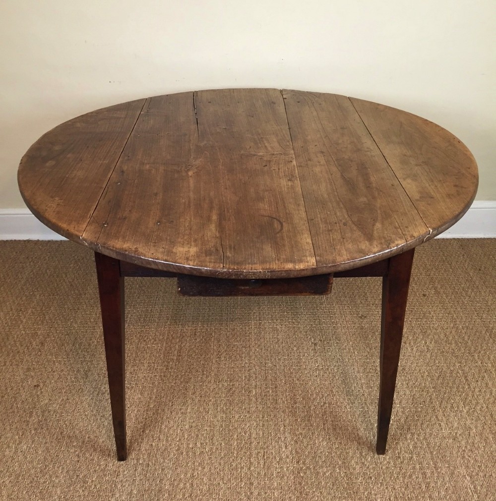 A French circular fruitwood folding table c 1860
