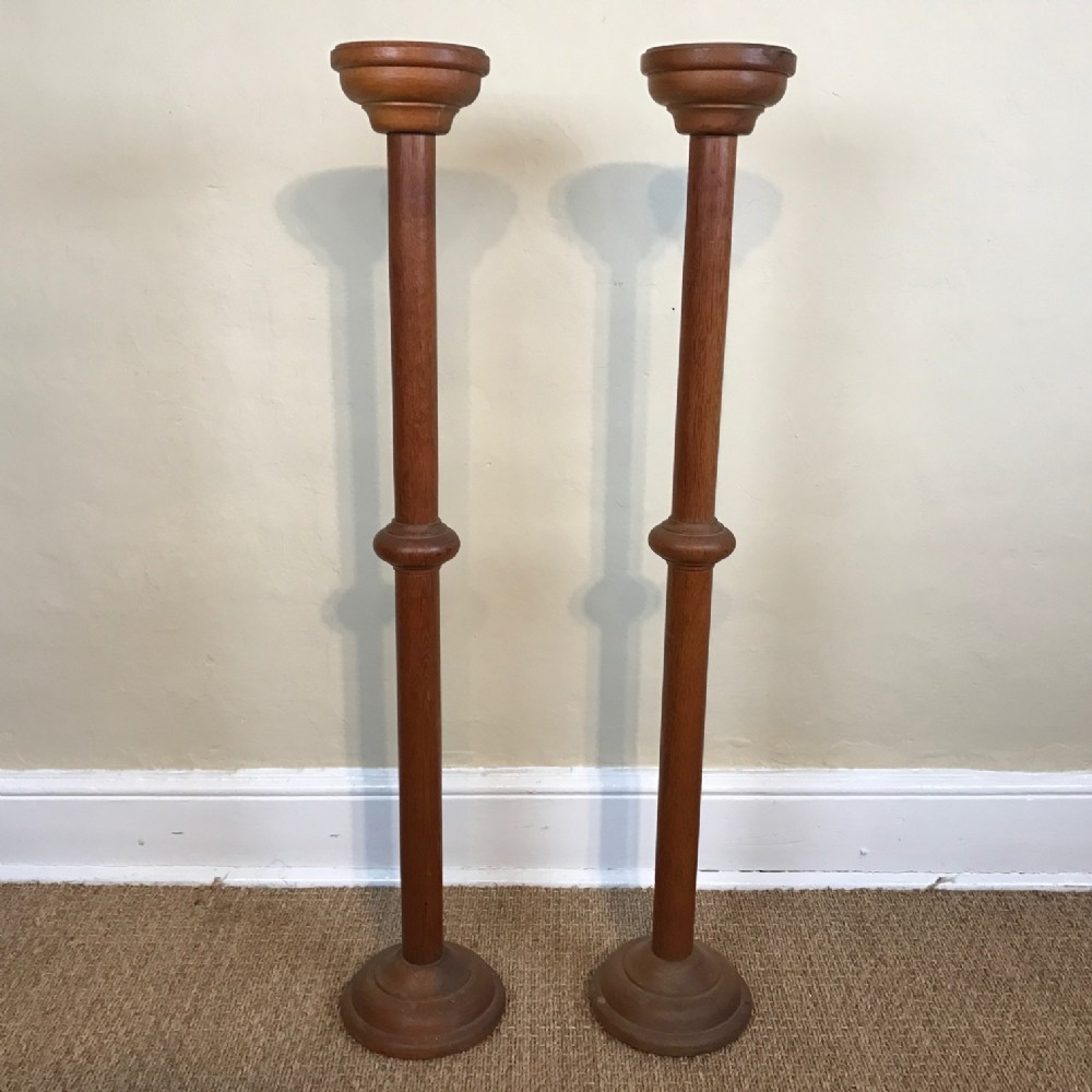 A pair of Arts and Crafts oak candle stands circa 1910 