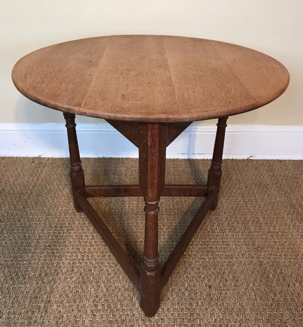 An Arts and Crafts oak cricket table circa 1910 in the style of Heals .