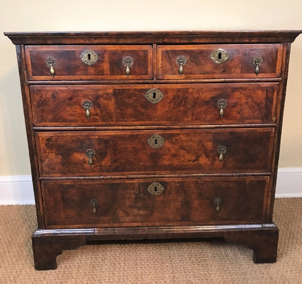 A George 1 walnut and feather banded  chest of drawers circa 1710