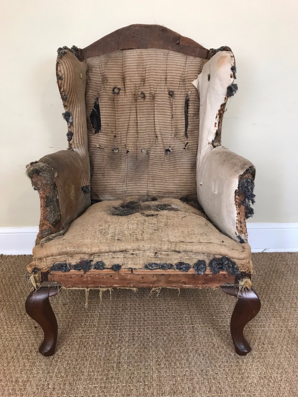 A late Victorian mahogany leg wing armchair circa 1890 for re upholstery.