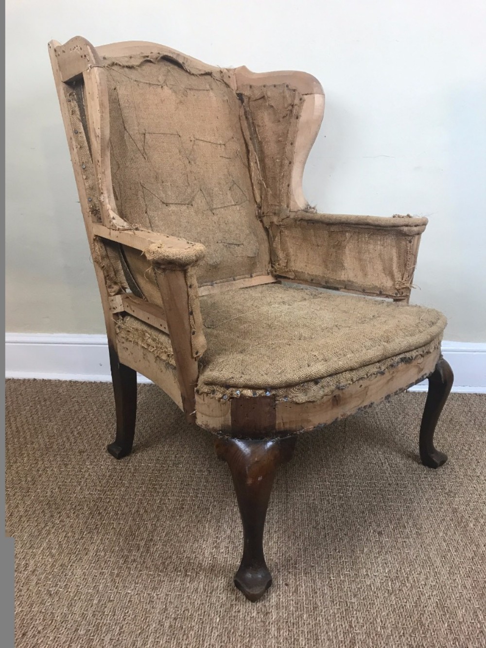 A late Victorian walnut wing armchair circa 1900 in George 11 style