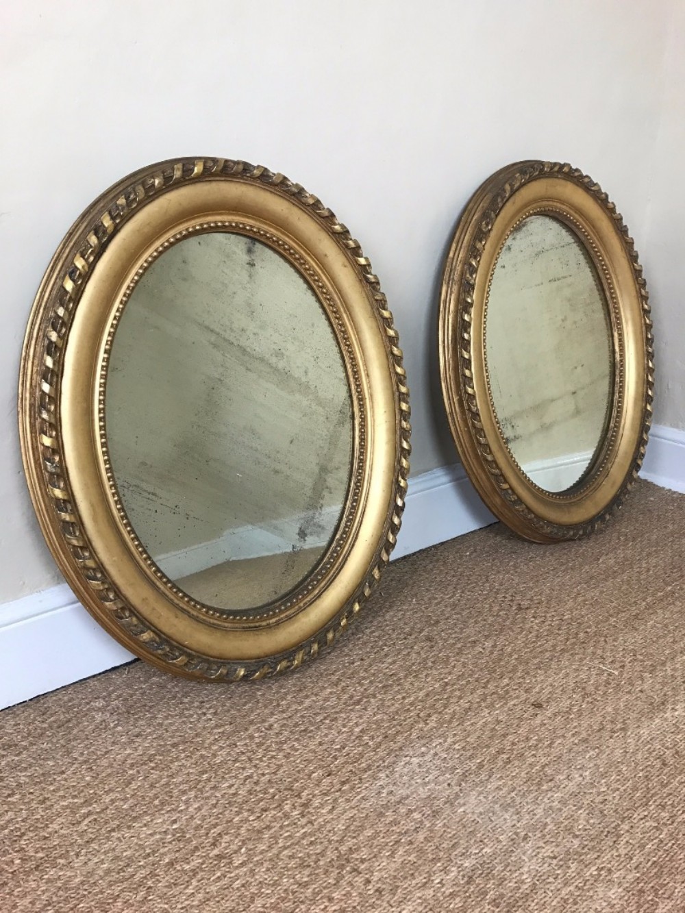 A pair of Victorian carved gilt wood oval mirrors circa 1870