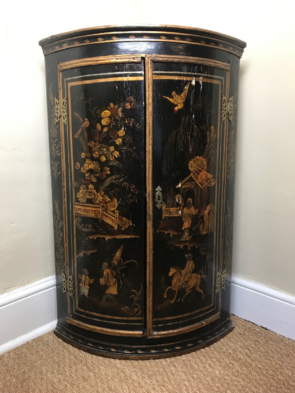 An early 18th century Chinoiserie lacquered corner cupboard circa 1730