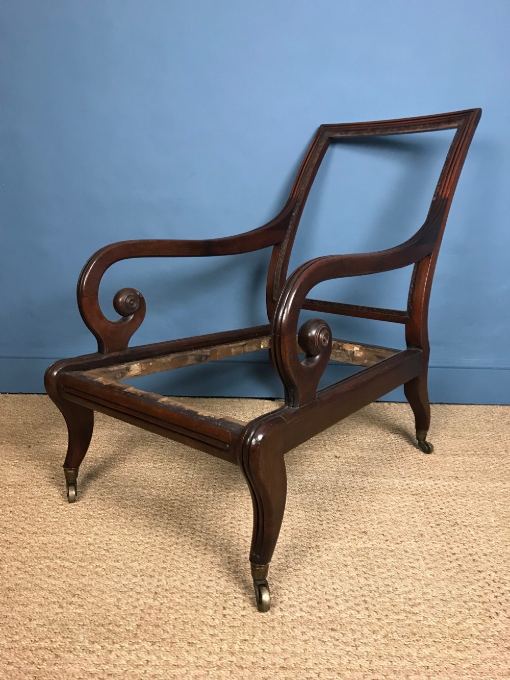 A large George IV mahogany deep seated library chair frame c 1830