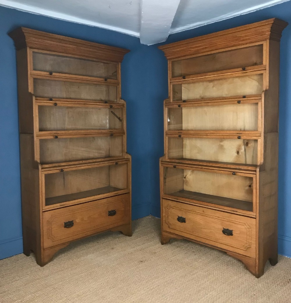 A pair of Edwardian golden oak glazed waterfall bookcases c 1910