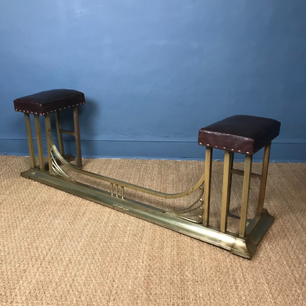 An Edwardian brass and leather club fender circa 1910