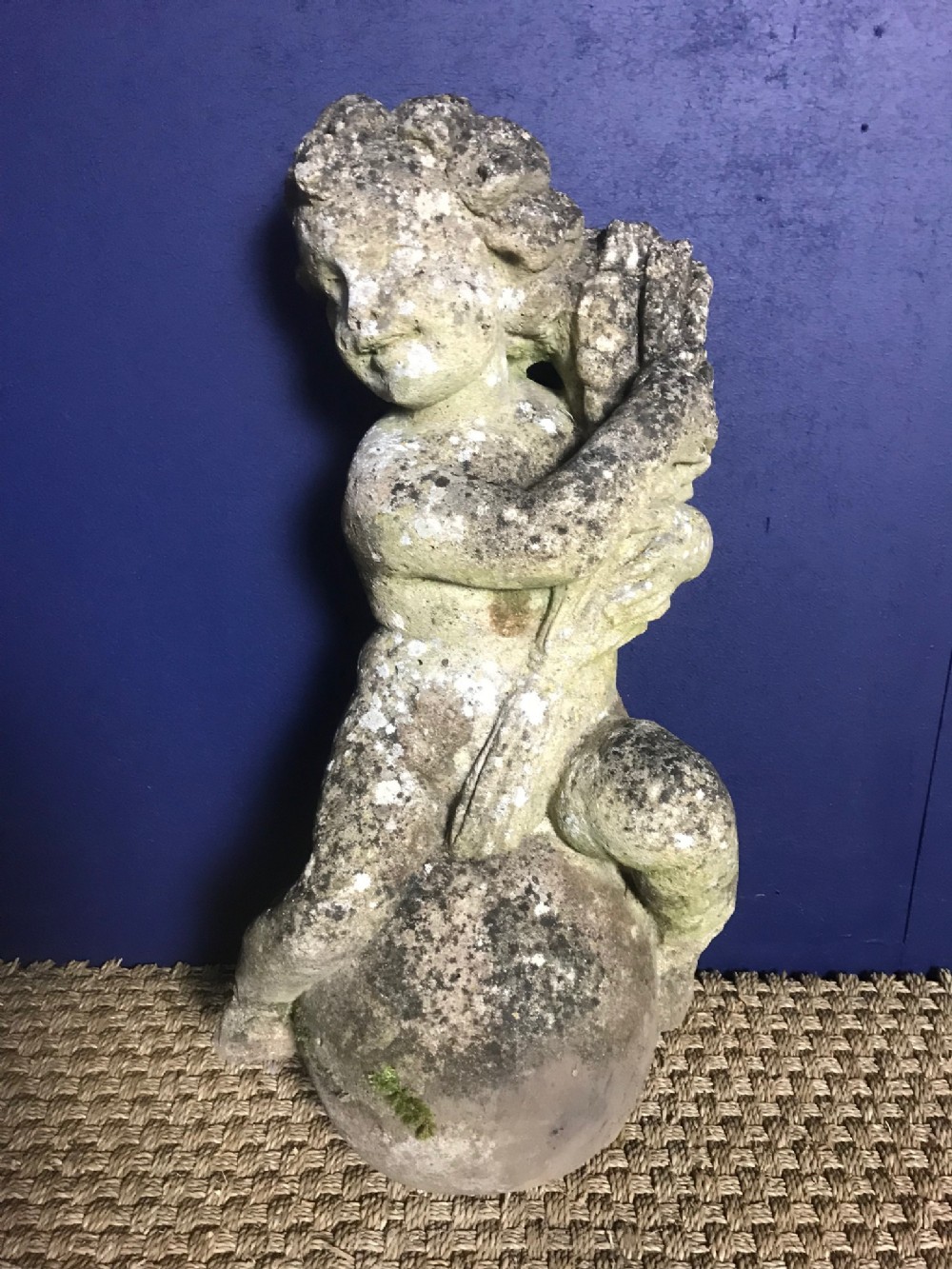 A Composite stone figure of a putto and a dolphin . English circa 1920