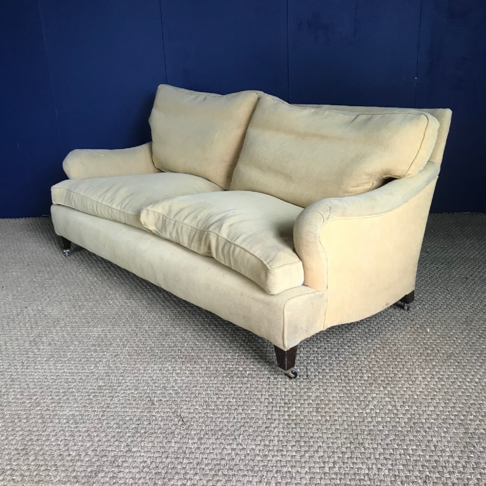 A 1920’s style two seater Howard Sofa on mahogany square tapering legs cappings and castors.