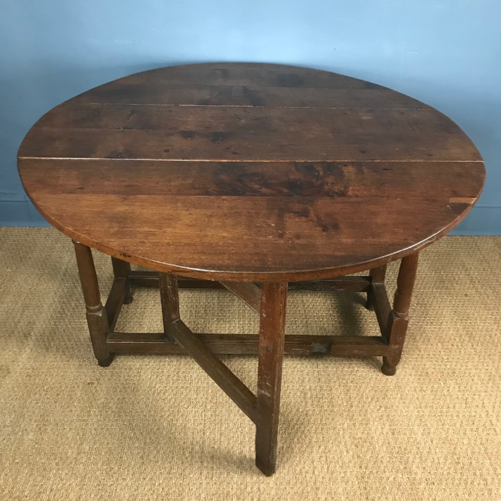An early 18th c oak gateleg table with oval drop flap top.