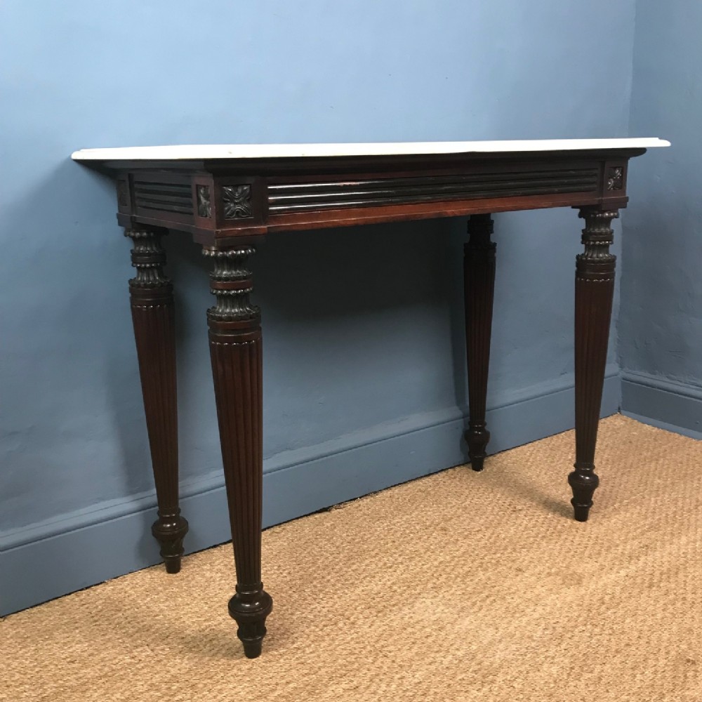 A George IV mahogany and ebonised console table circa 1825 with white marble top.