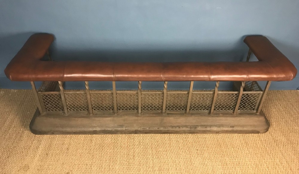 A large Edwardian iron wood and leather club fender circa 1910.