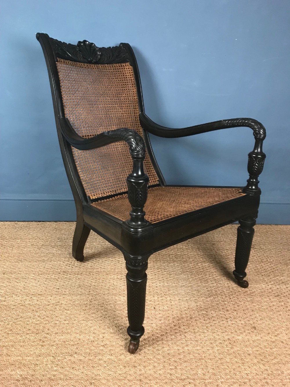 An Anglo Indian Ceylonese carved ebony bergere library chair. Galle circa 1850