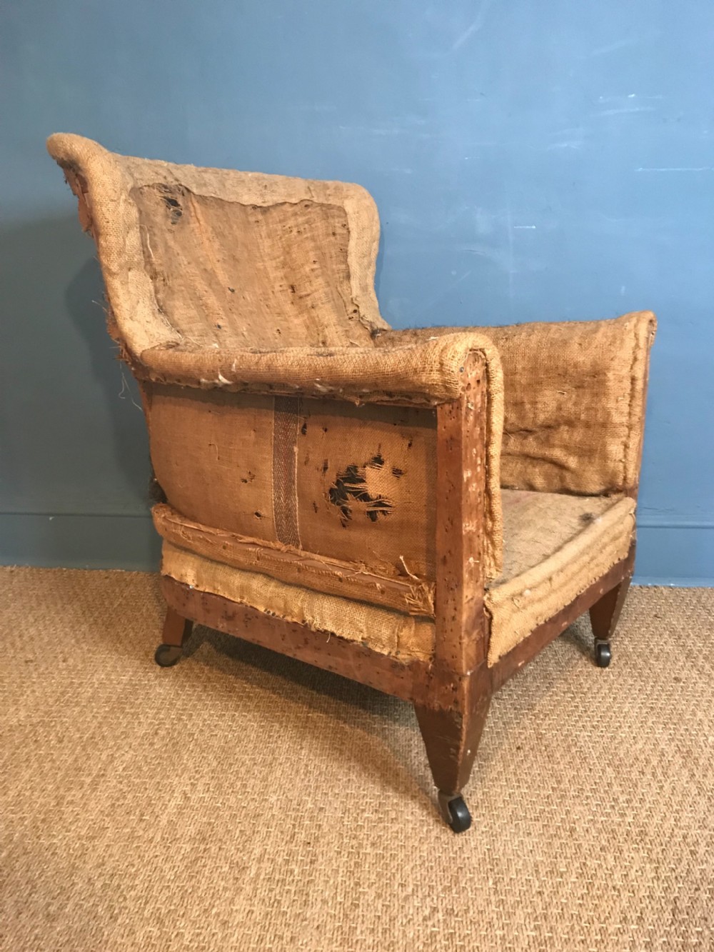 An Edwardian mahogany library chair circa 1910 stripped back ready for re-upholstery .