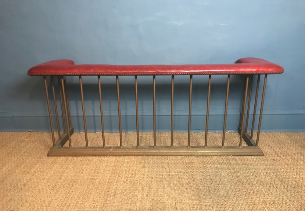 A late Victorian brass club fender c 1900 with original red leather top .