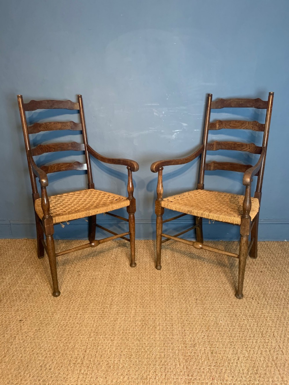A pair of Arts and Crafts oak elbow chairs circa 1900