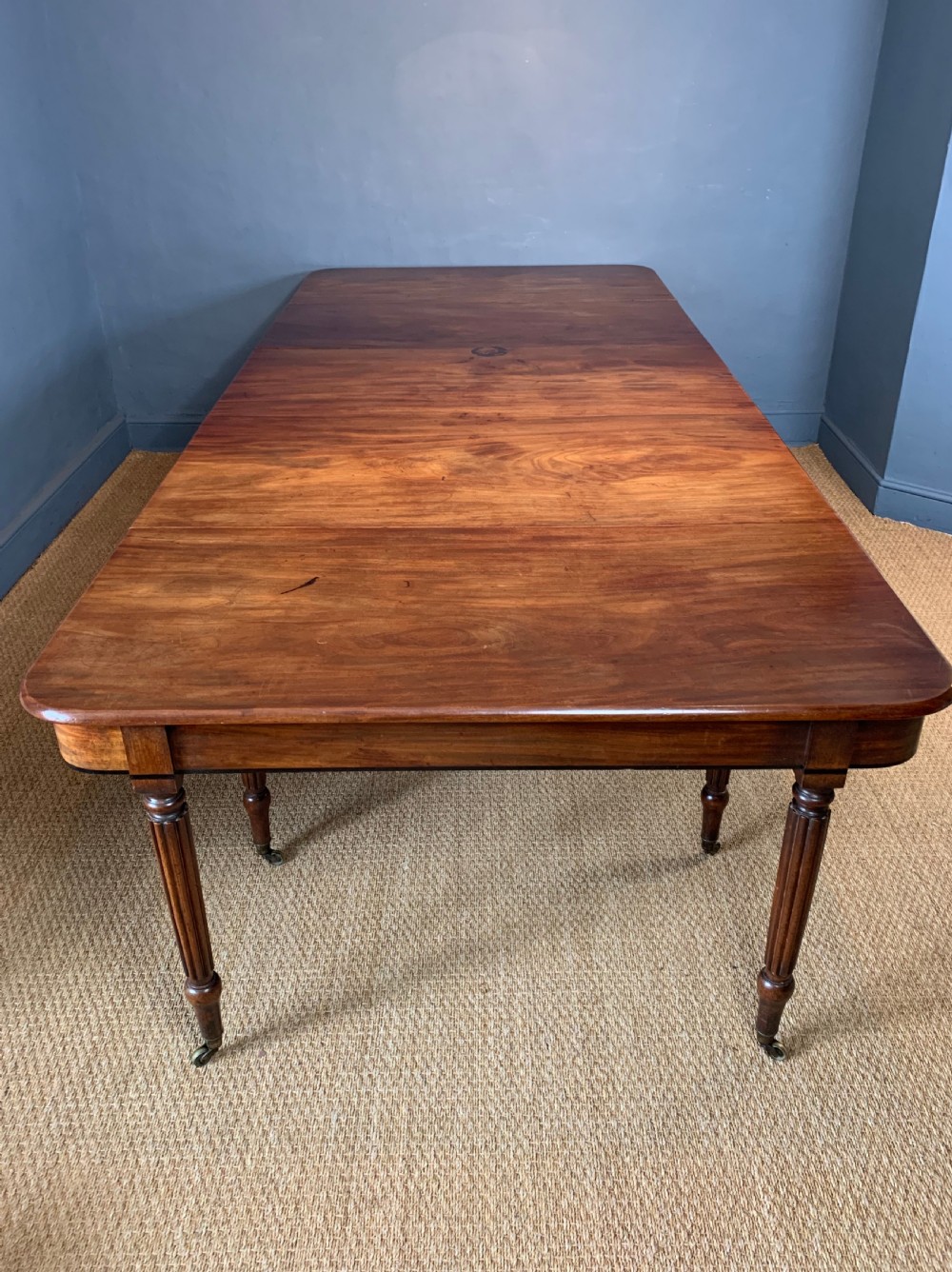  A superb George IV mahogany and ebony strung extending dining table circa 1820