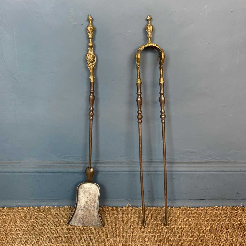 A pair of Victorian Gothic gilt brass and steel fire irons circa 1870.