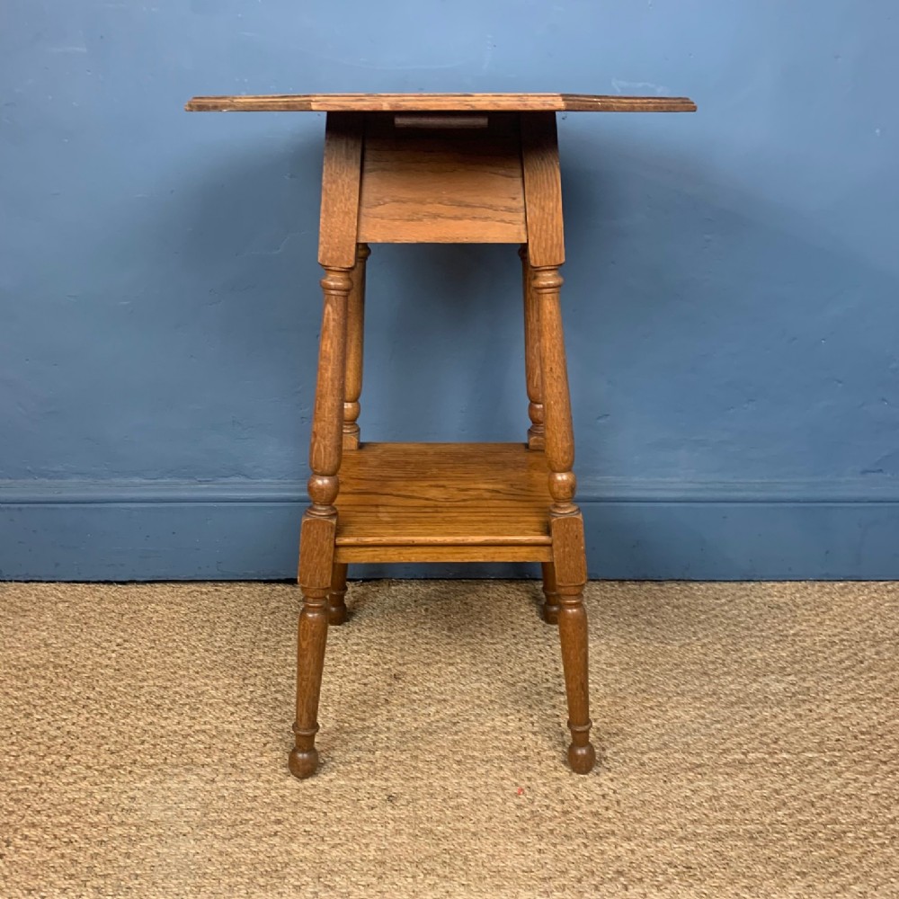 An Arts and Crafts oak octagonal two tier lamp table circa 1910