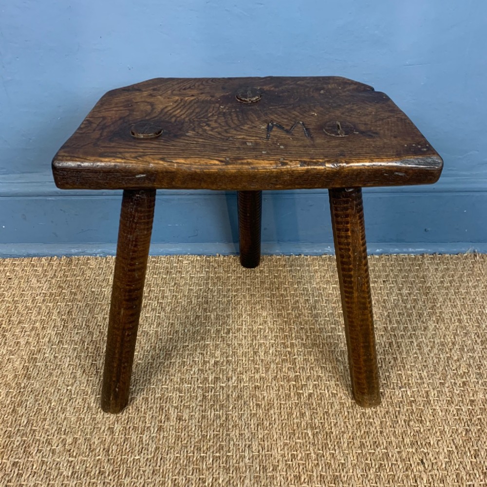 An early 19th century elm three legged Cutlers Stool 