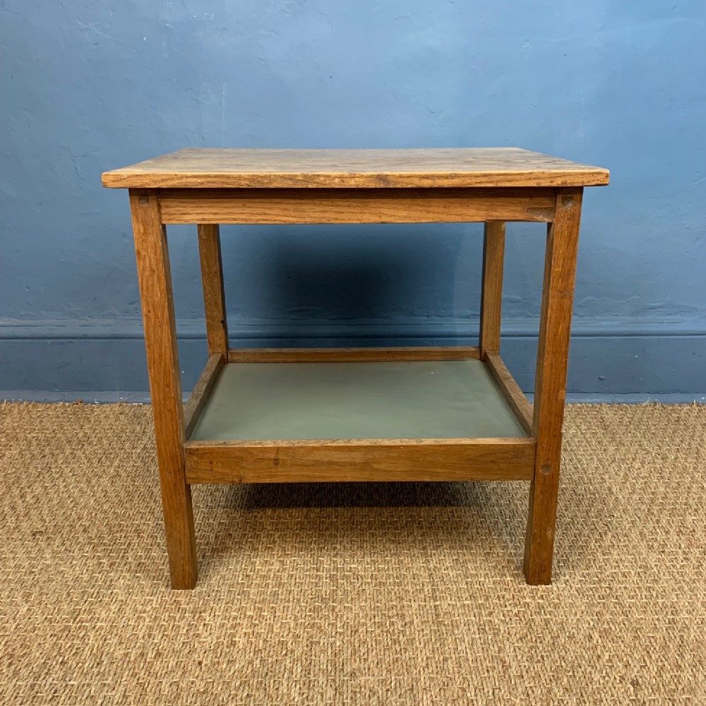 A Cotswold School oak 2 tier table circa 1930 .