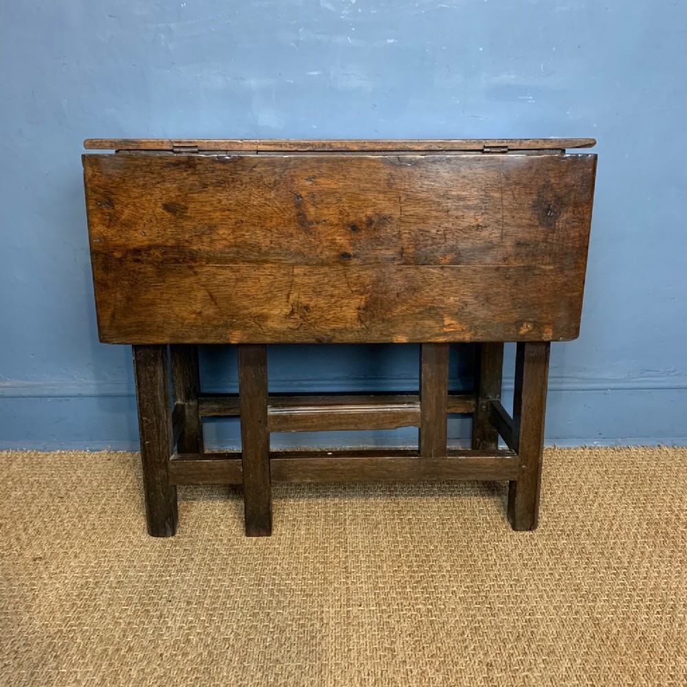 A late 17th Century oak single drop flap side table