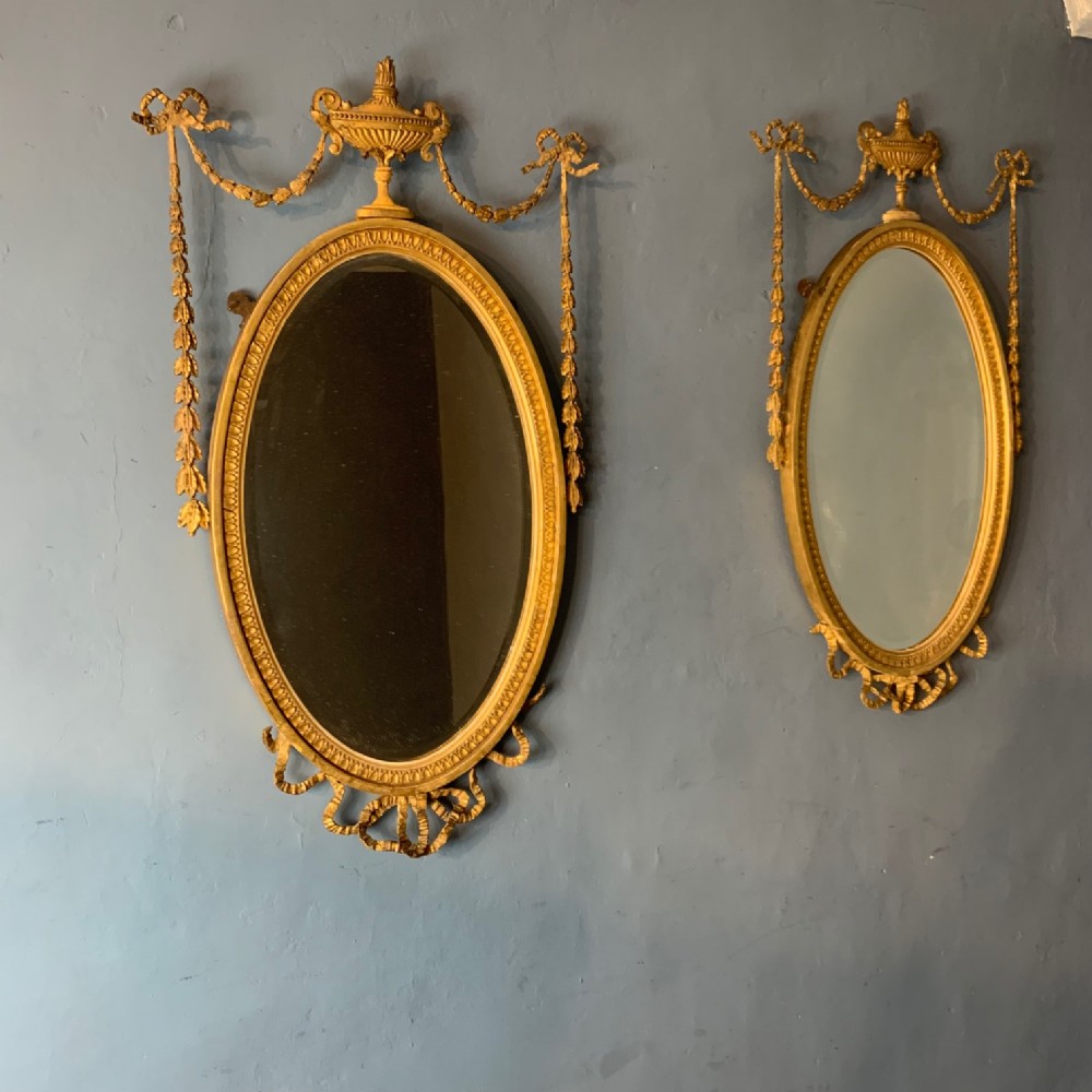 A pair of late 19th c Adam design oval mirrors circa 1890