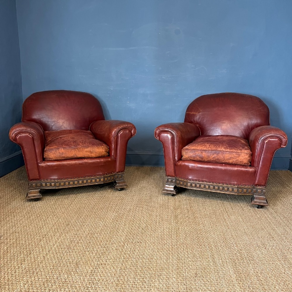 A pair of English red leather and oak armchairs circa 1920