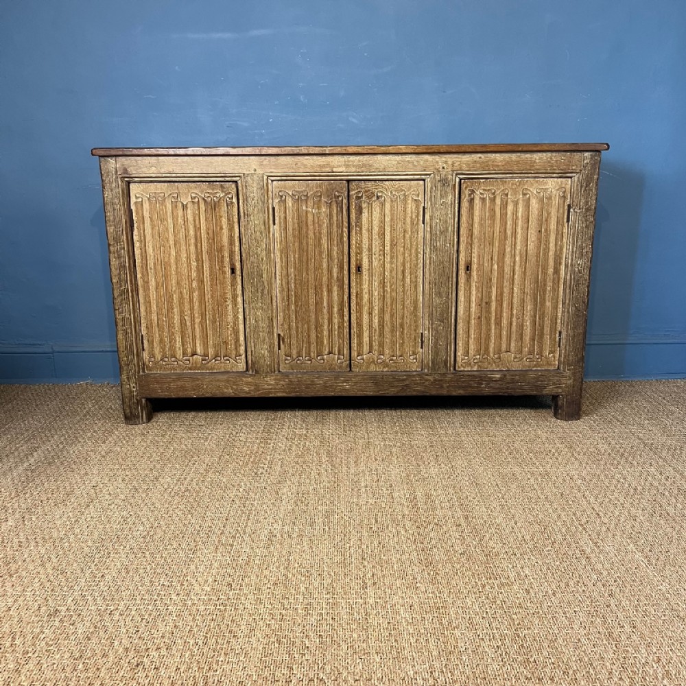 A late 19th c limed oak linenfold panelled side cabinet or dresser 