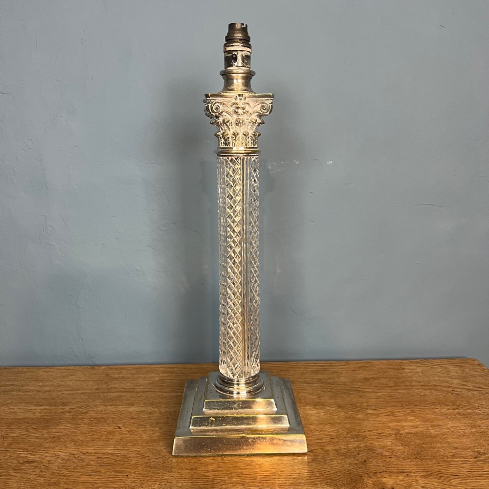 An Edwardian table lamp featuring a diamond-cut crystal column mounted on a stepped silver-plated square base with a Corinthian capital.