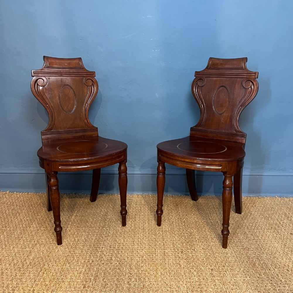 A pair of George 111 Hepplewhite period mahogany hall chairs circa 1790