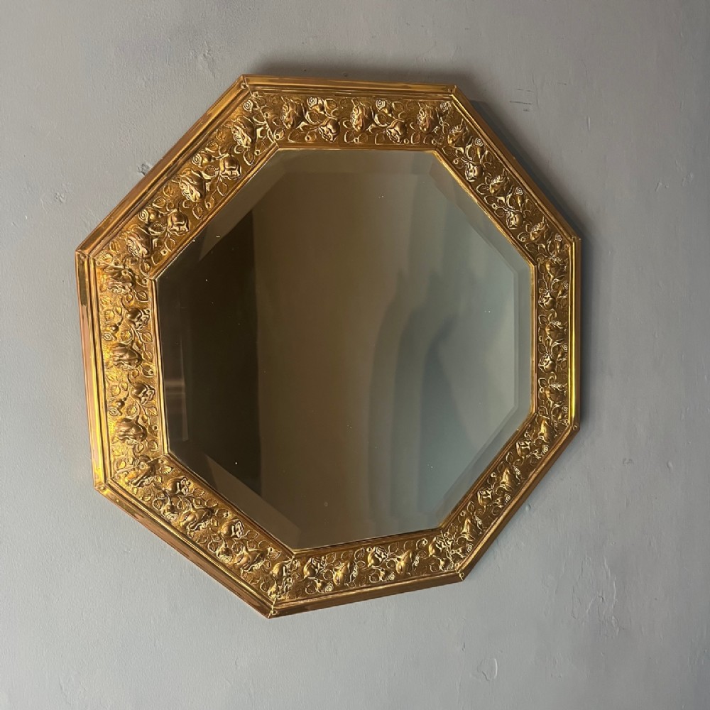 An Arts and Crafts brass embossed octagonal mirror circa 1890