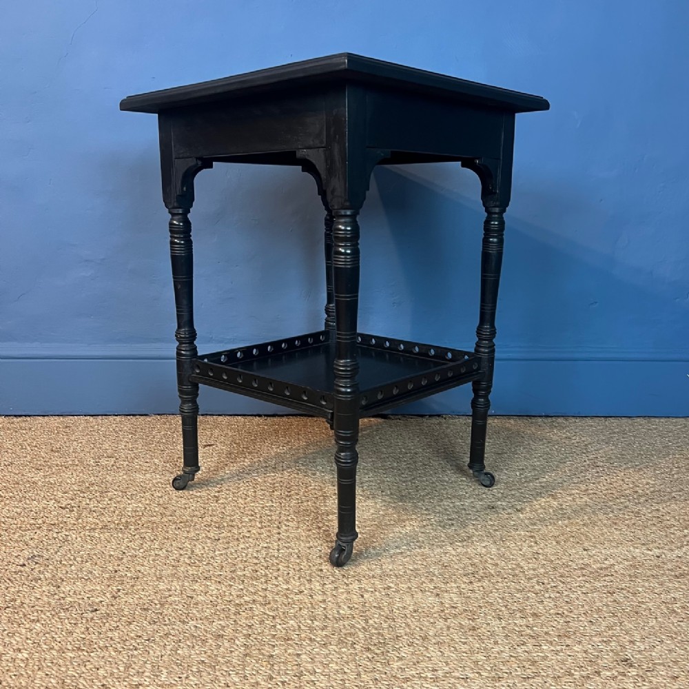 An Aesthetic Movement ebonised 2 tier table c 1880  after a design by E W Godwin .