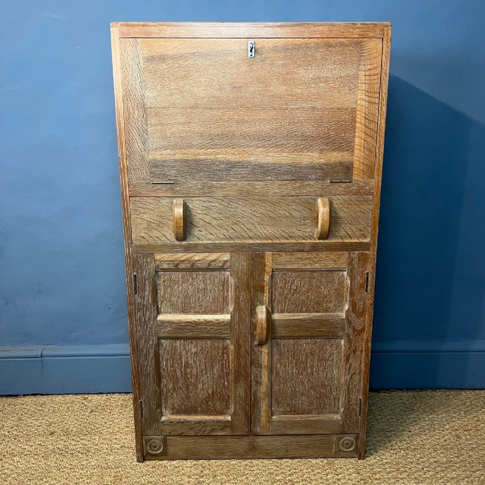 An Arts and Crafts limed oak small secretaire desk circa 1935