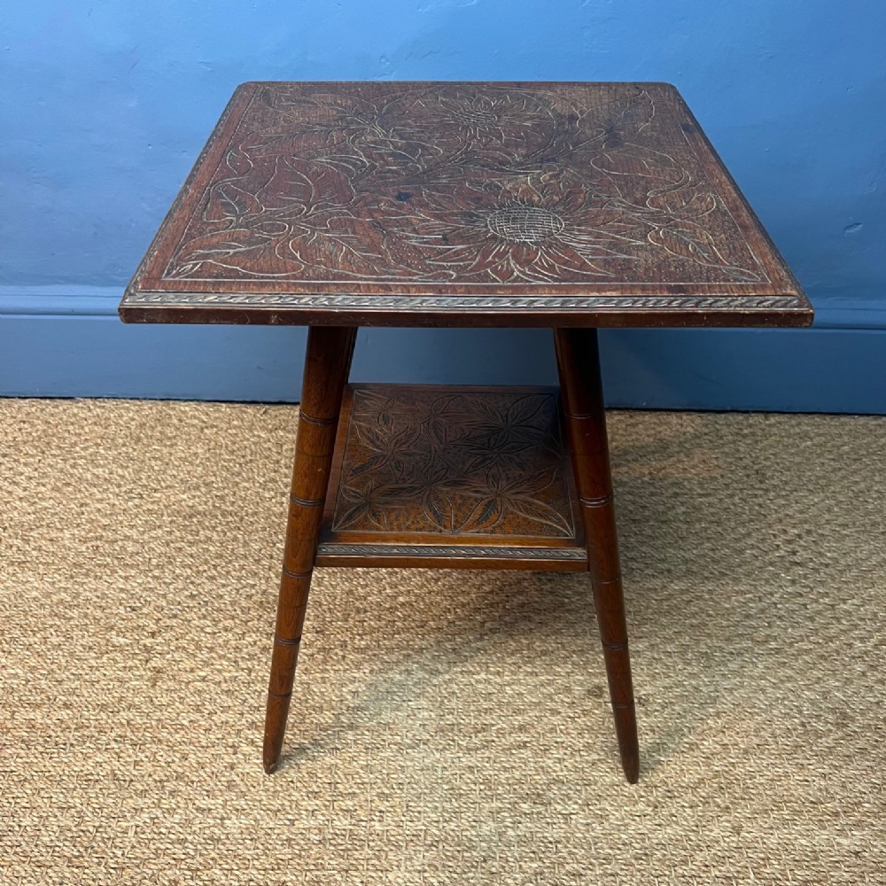A Liberty and Co carved walnut 2 tier table circa 1900 .