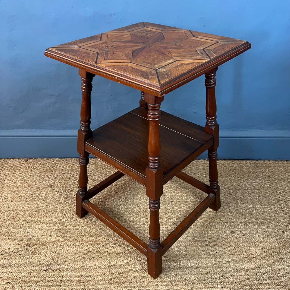 An Arts and Crafts walnut and parquetry 2 tier table circa 1900