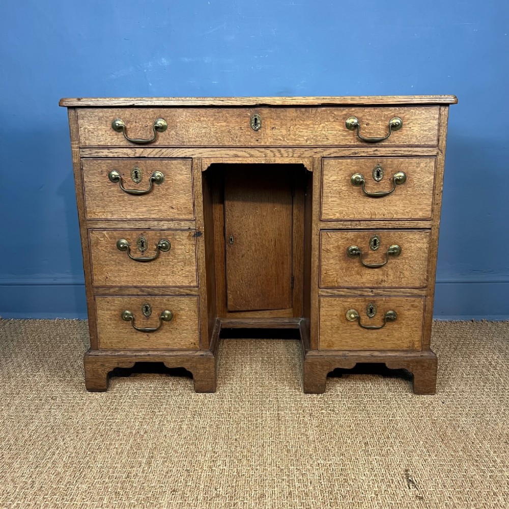 A George 111 faded oak kneehole desk circa 1780