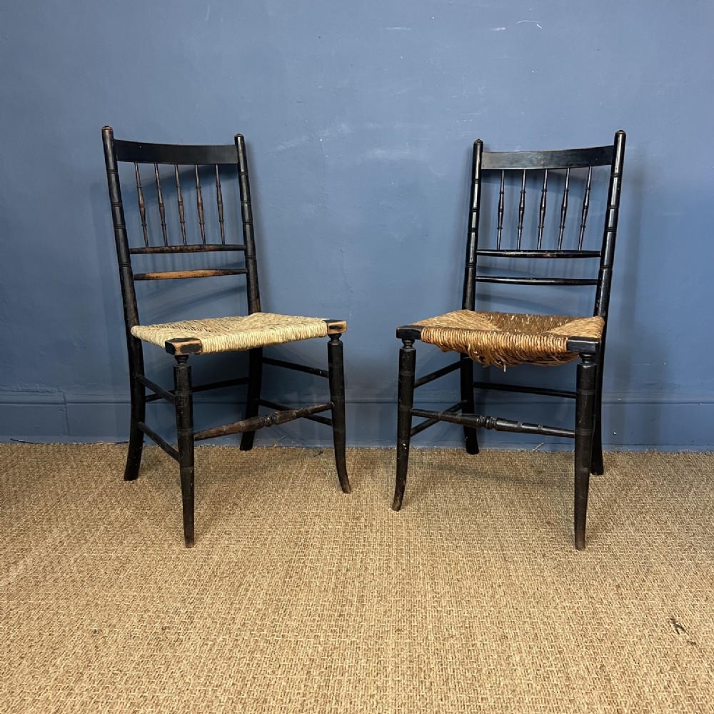 A pair of William Morris ebonised beech Sussex Armchairs to a design by Philip Webb circa 1880 