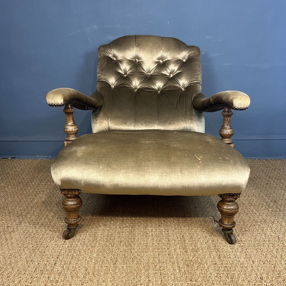 A late 19th-century Victorian open armchair with olive green velvet deep-buttoned upholstery, turned oak legs, and brass castors. View II